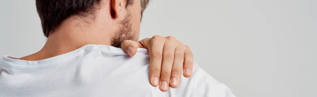 Man holding shoulder in pain due to shoulder injury